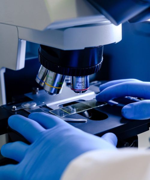 Un trabajador de laboratorio que trabaja con un microscopio moderno mientras realiza una investigación de coronavirus _ Foto Gratis